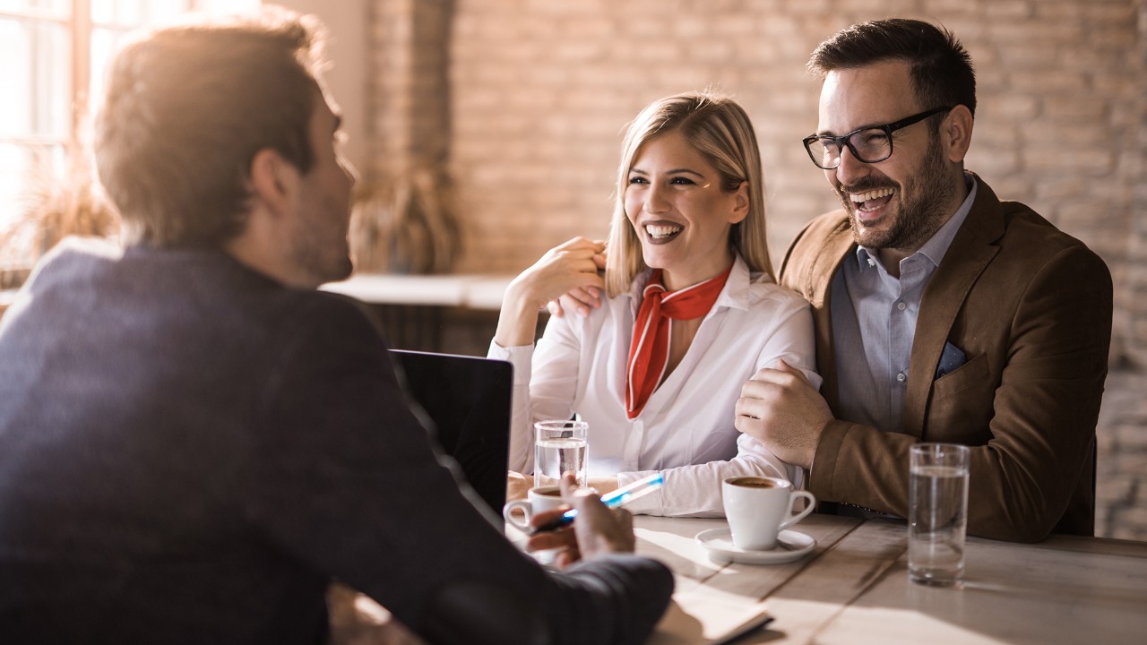 People talking with bank employee, smiling